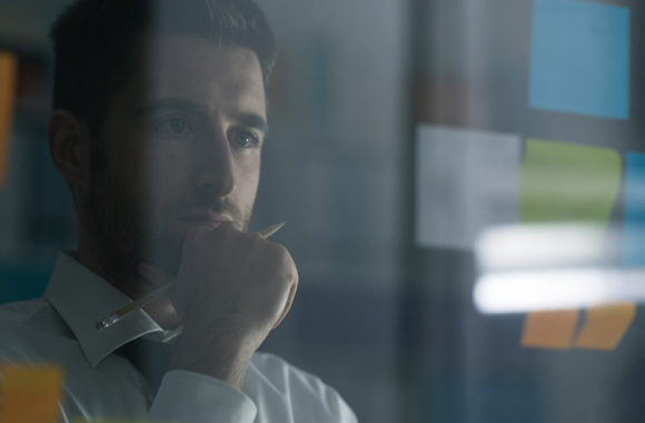 a man comtemplating and staring at the sticky notes